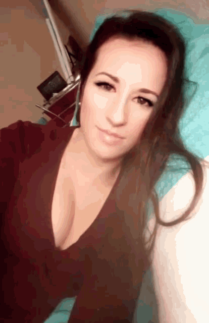 a woman laying on a bed with a very plunging neckline