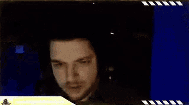 a man wearing headphones is looking at something in a dark room