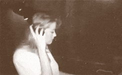 a woman in a white shirt is singing into a microphone .