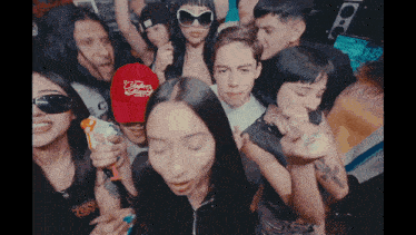 a group of people are posing for a picture and one of them is wearing a red hat that says ' victoria '