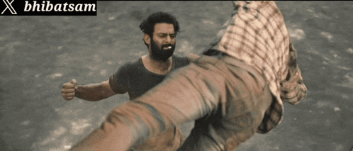 a man with a beard is kicking another man in the face with a sign that says x bhibatsam