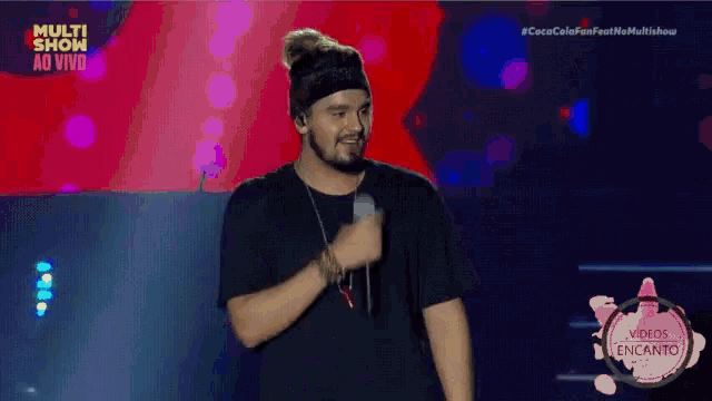 a man singing into a microphone in front of a screen that says multi show