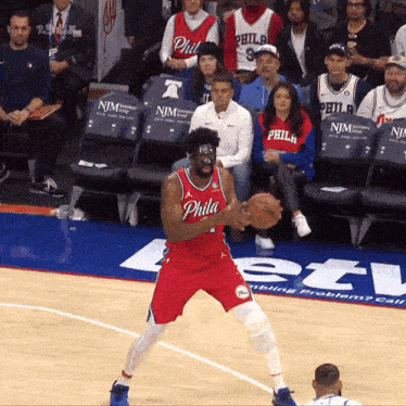 a philadelphia basketball player is holding a basketball