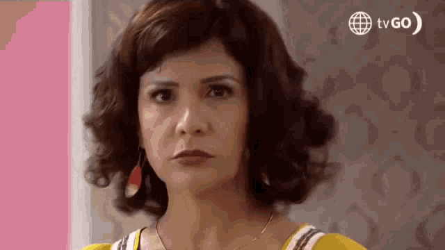 a close up of a woman 's face with a tv go logo in the corner