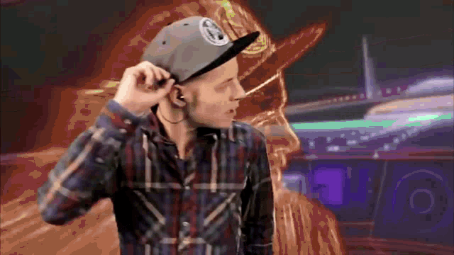 a man wearing a plaid shirt and a hat with a patch that says ' abercrombie & fitch ' on it