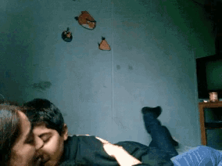 a man and woman are kissing in front of angry birds hanging on the wall