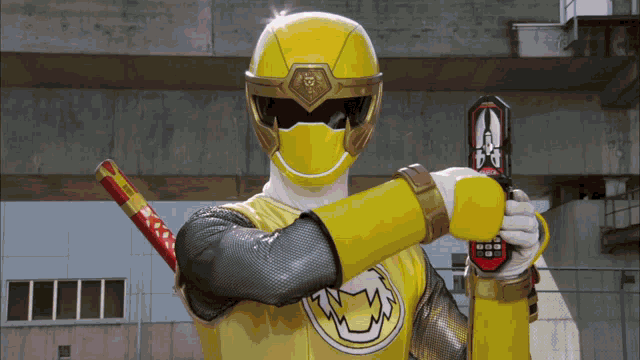 a yellow power ranger is holding a sword and a cell phone
