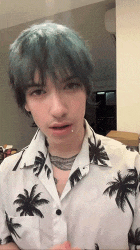 a young man with blue hair is wearing a palm tree shirt