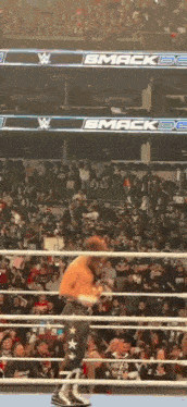 a wrestling match is taking place in front of a crowd and a sign that says smackdown