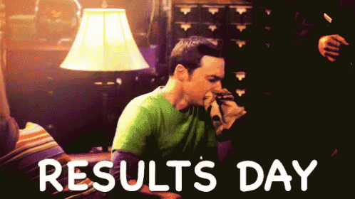 a man in a green shirt sitting in front of a lamp with the words results day written below him