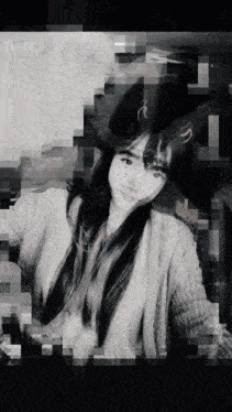 a black and white photo of a woman wearing a hat and sweater