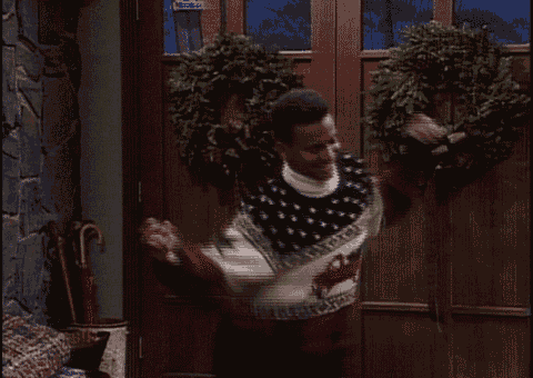a man in a sweater with a horse on it is standing in front of a door
