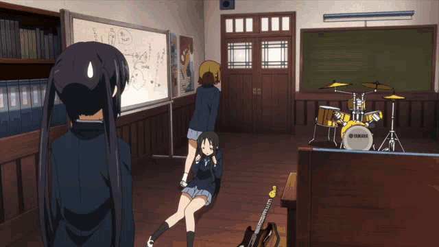 a yamaha drum set sits in a classroom with two girls
