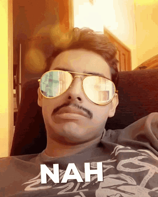 a man wearing sunglasses and a mustache has the word nah written below him