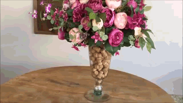 a vase filled with flowers and wine corks on a table