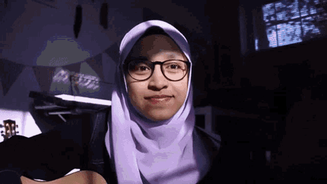 a woman wearing glasses and a purple head scarf