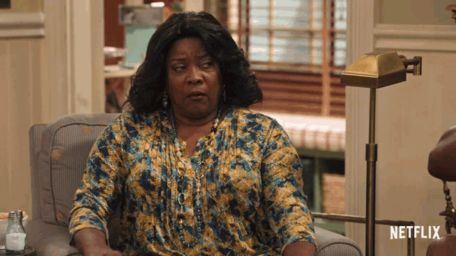 a woman is sitting in a chair with a netflix logo in the background