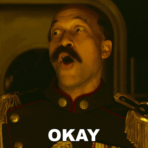 a bald man with a mustache is wearing a military uniform with the word okay below him