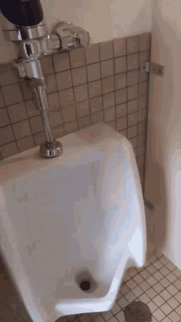 a urinal in a bathroom next to a wall