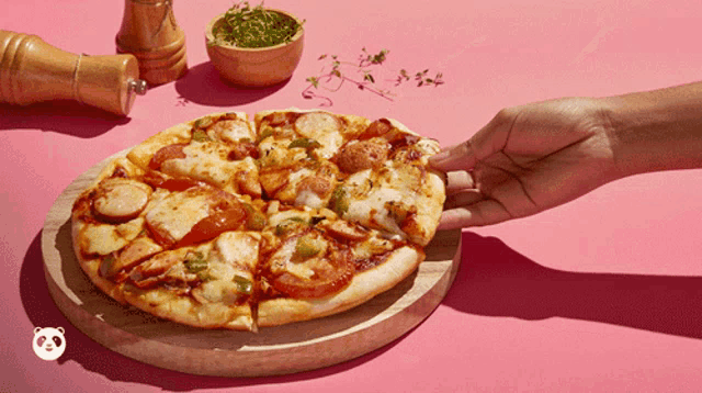 a person is taking a slice of pizza from a wooden board