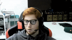 a man wearing headphones and glasses is sitting in a chair