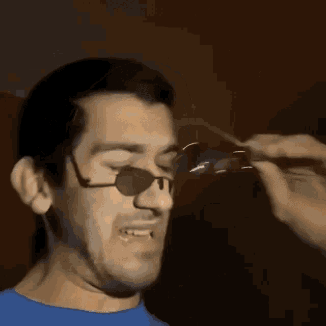 a man wearing sunglasses and a blue shirt that says " ao100 "