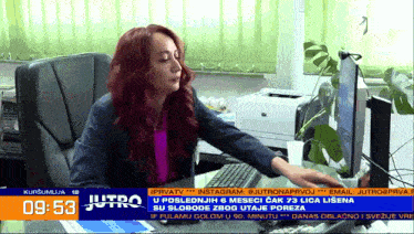 a woman sits at a desk in front of a computer screen that says jutro on the bottom