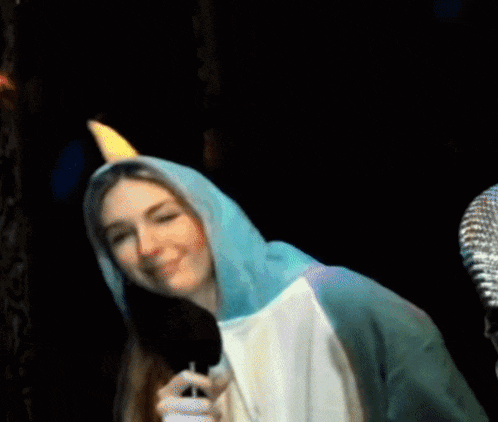 a woman in a unicorn costume is pointing at someone