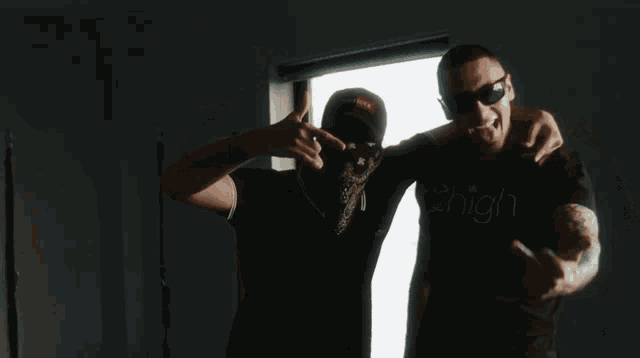 a man in a 2high shirt stands next to another man in a black shirt