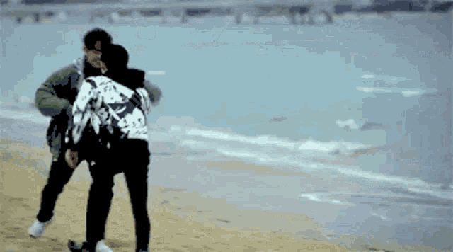 a man and woman are hugging on the beach