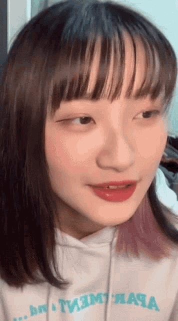 a close up of a girl 's face wearing a white hoodie that says tmt