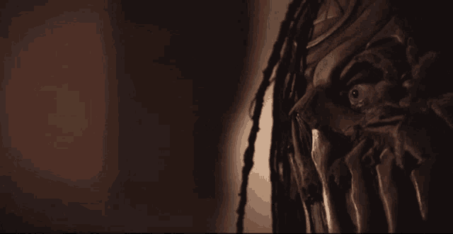 a close up of a monster 's face with dreadlocks and sharp teeth