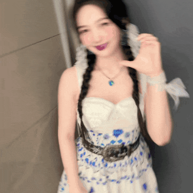 a woman wearing a white dress with blue flowers and a necklace