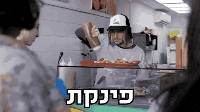 a man wearing a white hat with the letter l on it is preparing food