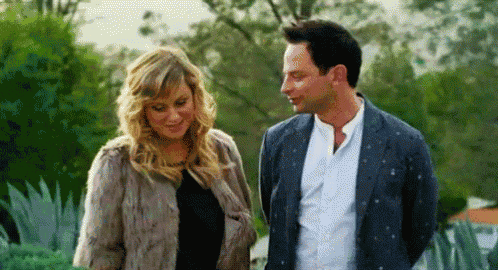 a man and a woman are standing next to each other and looking at each other