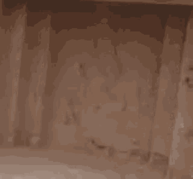 a close up of a hole in a wooden wall .