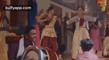 a group of people are dancing in a room with a drummer .