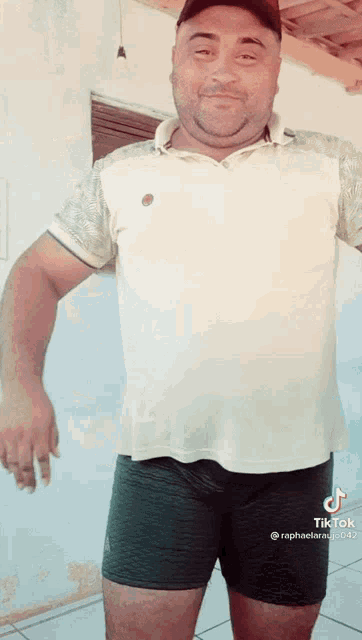 a man wearing shorts and a white shirt with tiktok written on the bottom right