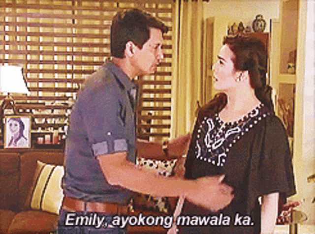 a man and a woman are standing in a living room and emily ayokong mawala ka