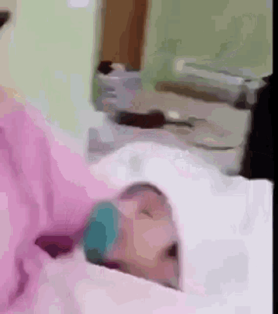 a baby is laying in a hospital bed with a nurse holding it .