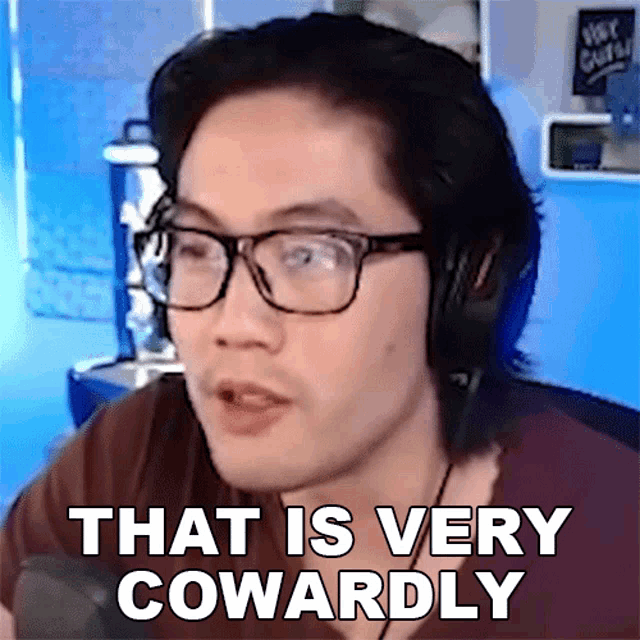 a man wearing glasses and headphones says " that is very cowardly "