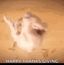 a turkey is sitting on a table with its mouth open and a happy thanksgiving greeting .