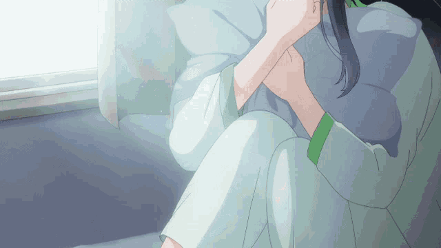 a woman sitting on a bed with a pillow in her lap