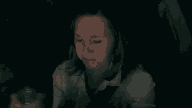 a woman is crying while sitting in a car at night
