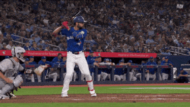 a baseball player in a blue jays uniform is swinging his bat