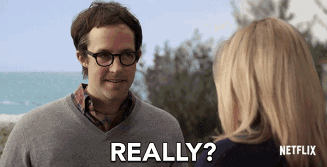 a man with glasses is talking to a woman and the words really are on the screen