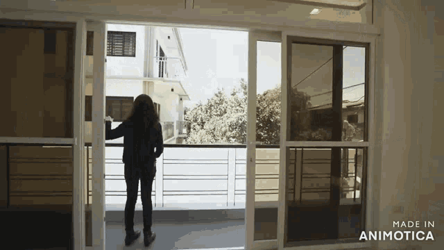 a woman is standing in front of a sliding glass door made by animatica