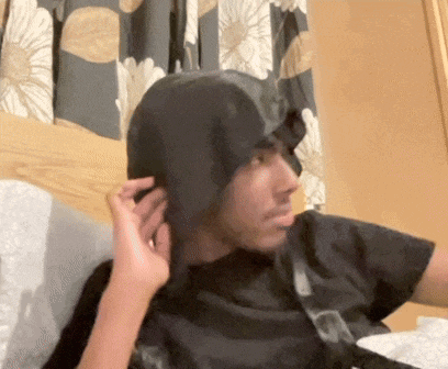 a person is putting a black hat on a person 's head