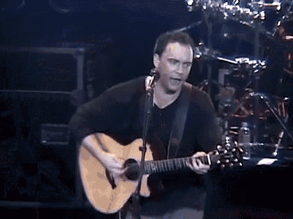 a man is playing an acoustic guitar on stage .