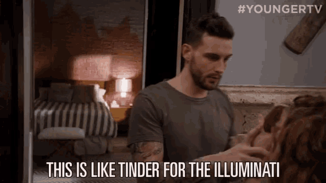 a man is talking to a woman in a room and says this is like tinder for the illuminati